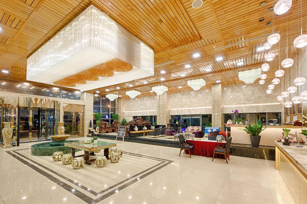 a large lobby with tables and chairs in a building at Nhu Minh Plaza Danang Hotel in Danang