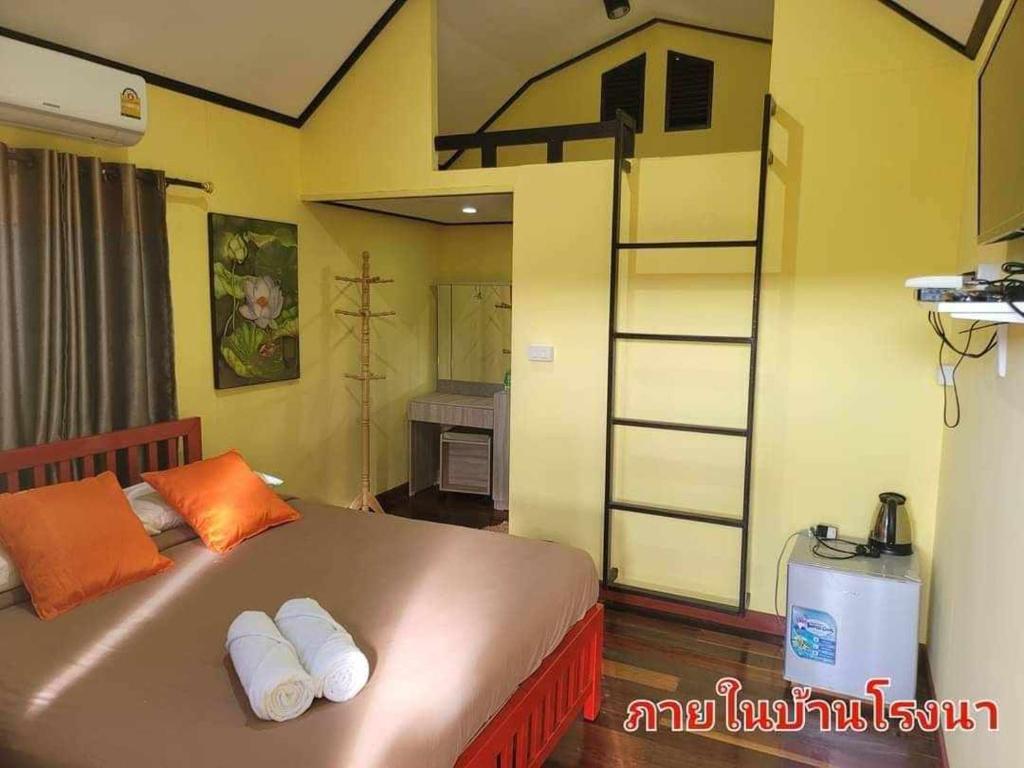 a bedroom with a bed with orange pillows and a ladder at The Memorize Resort in Ban Non Na Yao