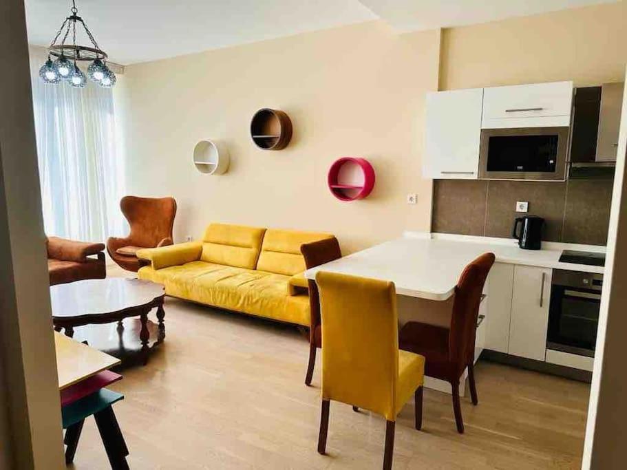 salon z żółtą kanapą i stołem w obiekcie Apartment with a lake view in Istanbul koza park borgaz w mieście Esenyurt