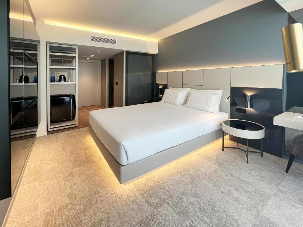 um quarto com uma grande cama branca e uma mesa em Oca Bom Sucesso Hotel no Porto