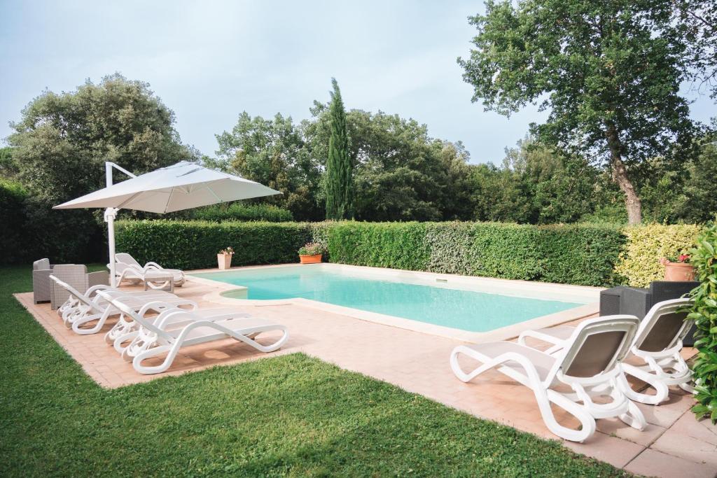 una piscina con tumbonas y sombrilla en Villa San Giusto - Pool&Relax en Montemassi