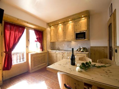 a kitchen with a table with a bottle of wine on it at Bike&Ski Saroch Apartments in Livigno