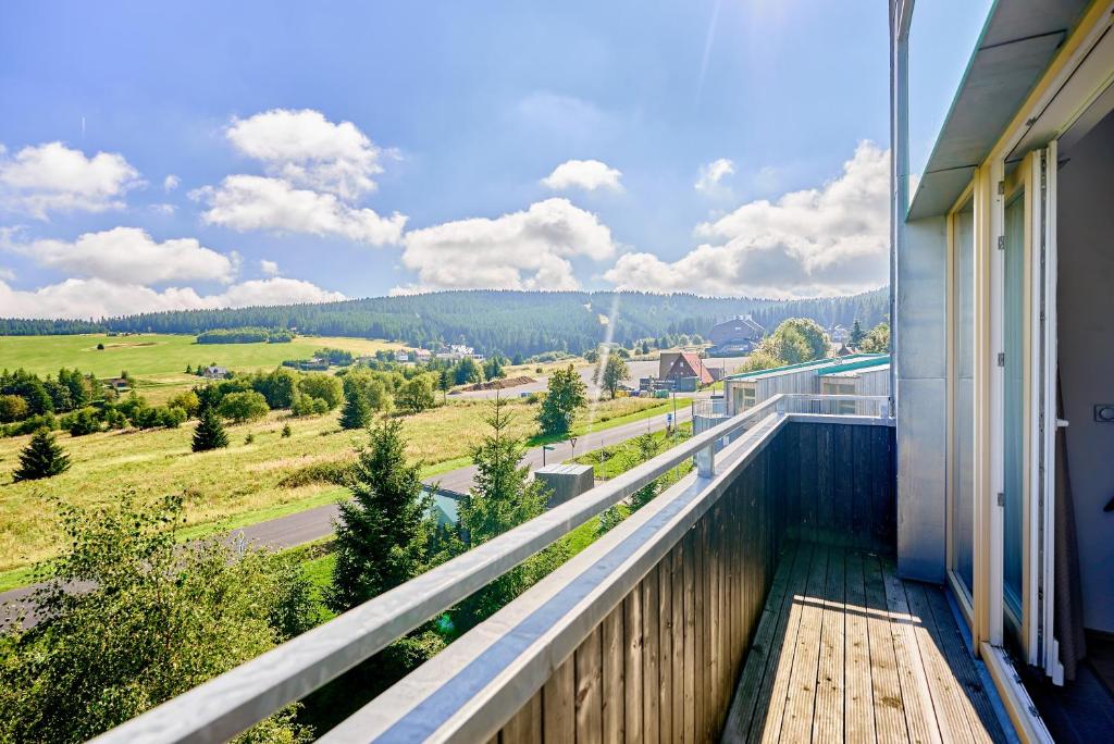 einen Balkon mit Blick auf ein Feld in der Unterkunft SlopeSide by Mountain ways in Loučná pod Klínovcem