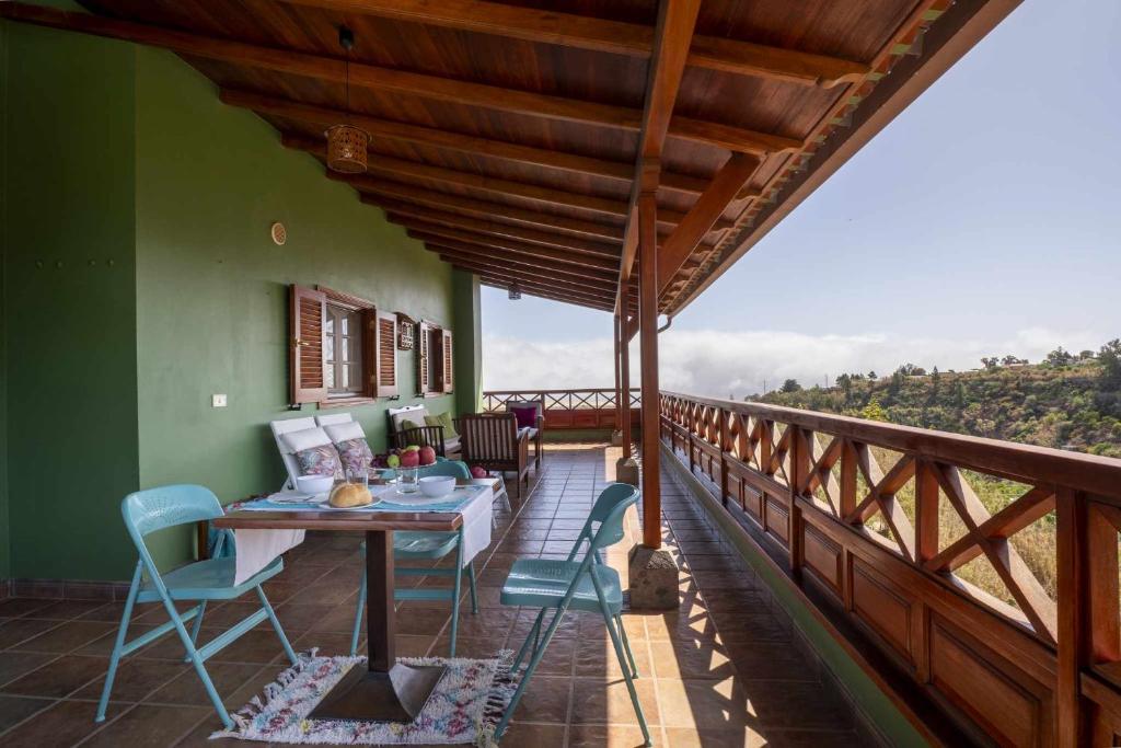 Habitación con balcón con mesa y sillas. en Casa Rural Gran Canaria El Cañaveral, en Vega de San Mateo