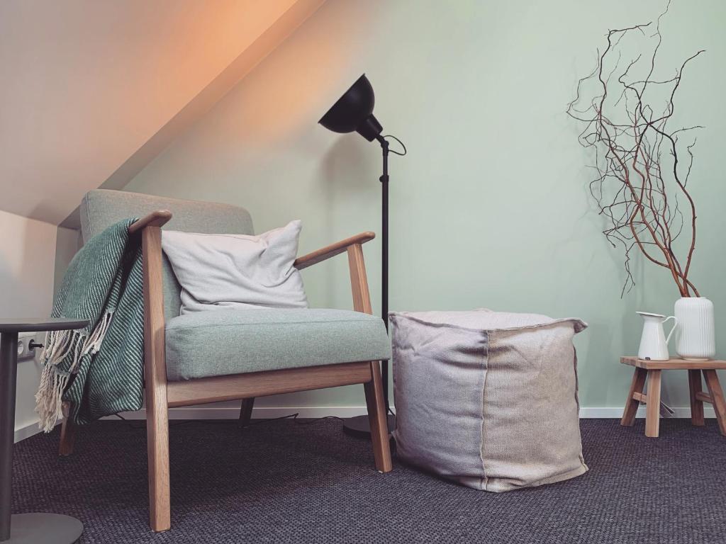 silla con almohada y lámpara en la habitación en Landhotel Stöckener Hof, en Rethem