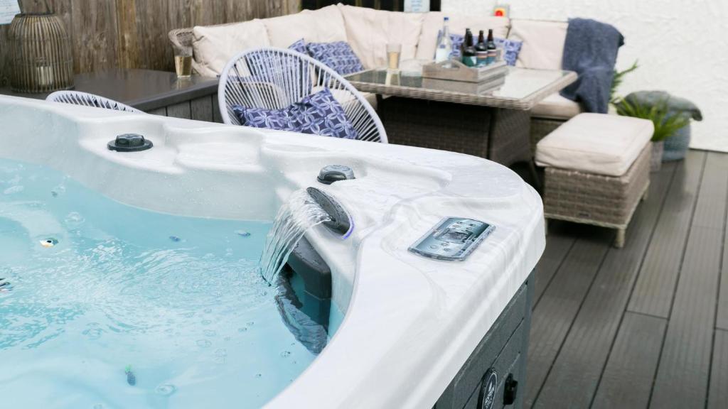 a jacuzzi tub with a remote control in it at Bryn Rhosyn in Benllech