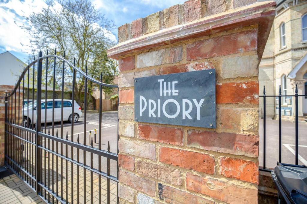 a sign on the side of a brick building with a life priority sign at Two Bedroom Duplex Apartment The Priory in St. Ives