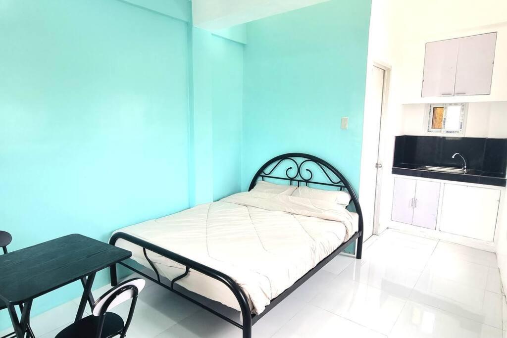 małe łóżko w pokoju z niebieską ścianą w obiekcie Riverfront Residence in San Carlos, Pangasinan 