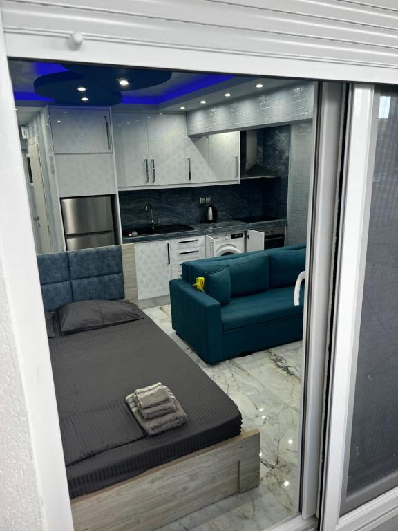 a living room with a blue couch and a kitchen at ΧΑΝΙΟΤΗ LUXURY STUDIOS 2 FIRST SEA BY MAKHMOME in Hanioti