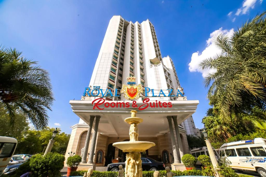 a hotel with a fountain in front of a building at Hotel The Royal Plaza in New Delhi