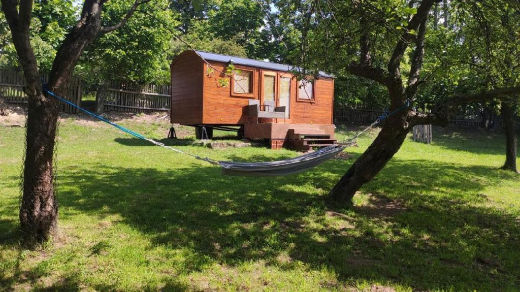 a hammock hanging between two trees in a yard at Maringotka/tiny house SEN VYSOČINA in Věstoňovice