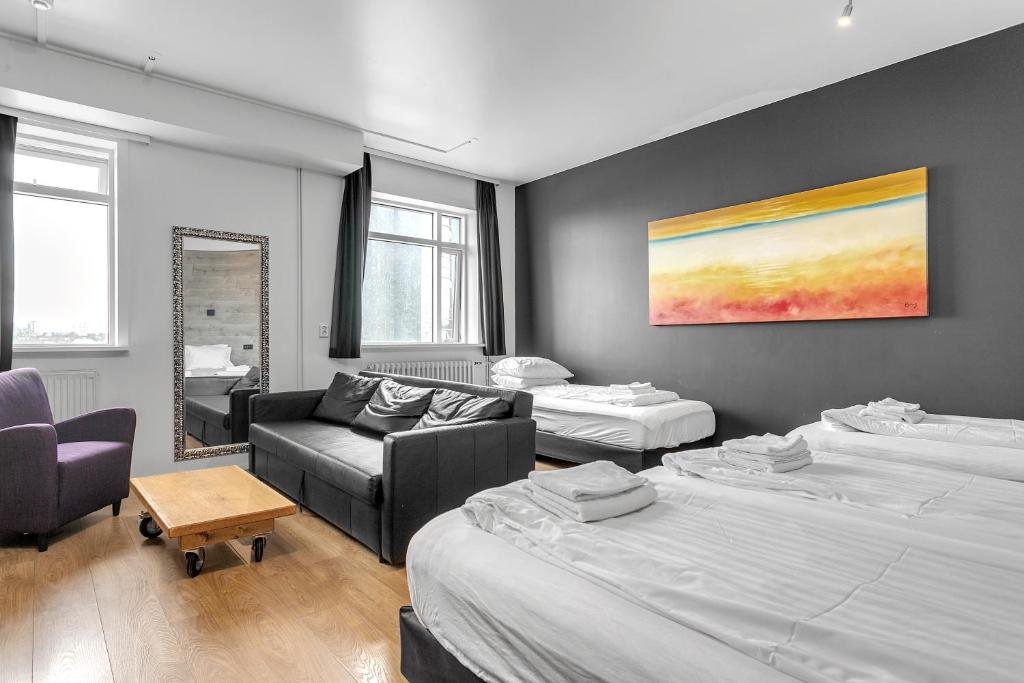 a hotel room with two beds and a couch at Stay Apartments Bolholt in Reykjavík