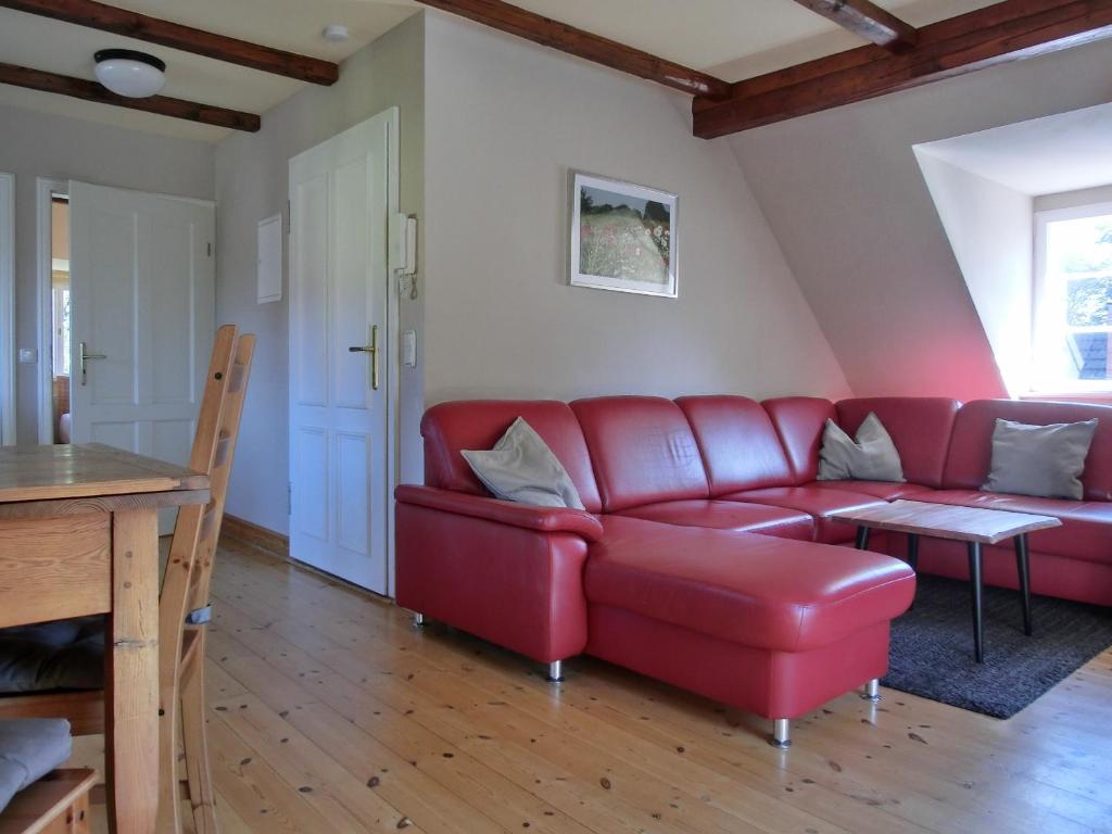 a living room with a red couch and a table at Strandstraße 60 Ferienwohnung S16 in Graal-Müritz