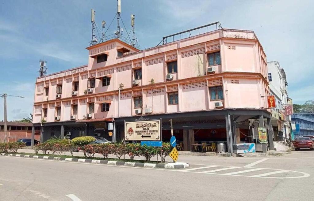 a large pink building on the corner of a street at Rz Gold Hotel Official Account in Kuala Kerai