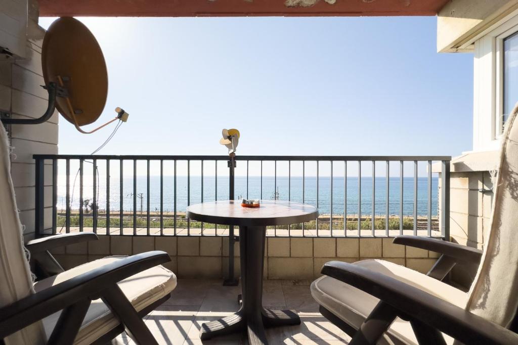 balcone con tavolo, sedie e vista sull'oceano di Impresionante Apartamento delante del Mar a Vilassar de Mar