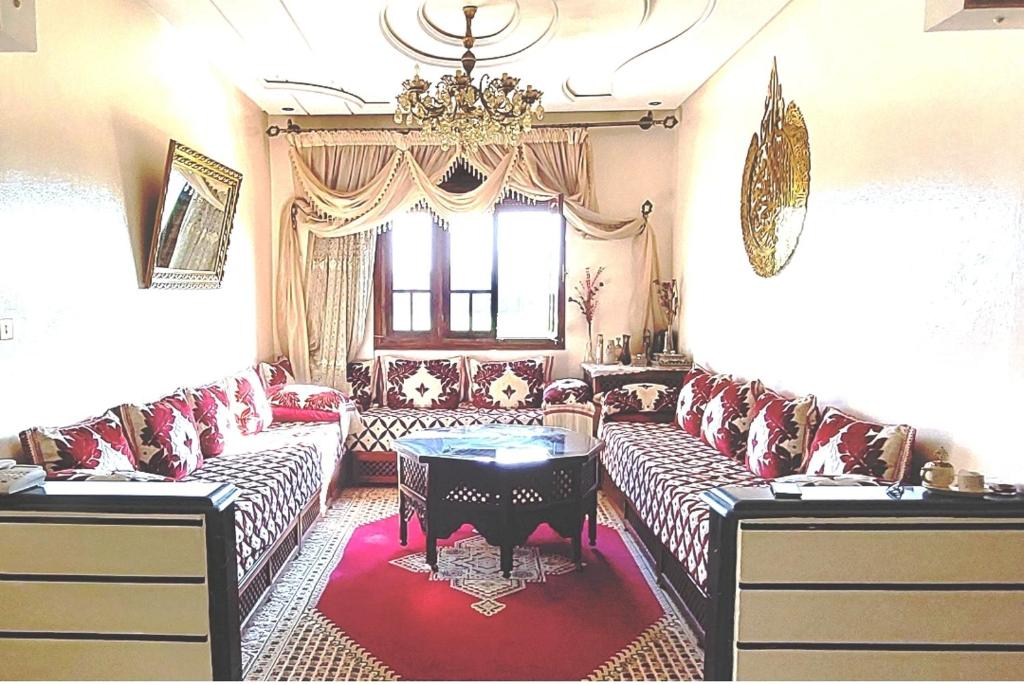 a living room with couches and a chandelier at Appartement meublé à louer in Meknès