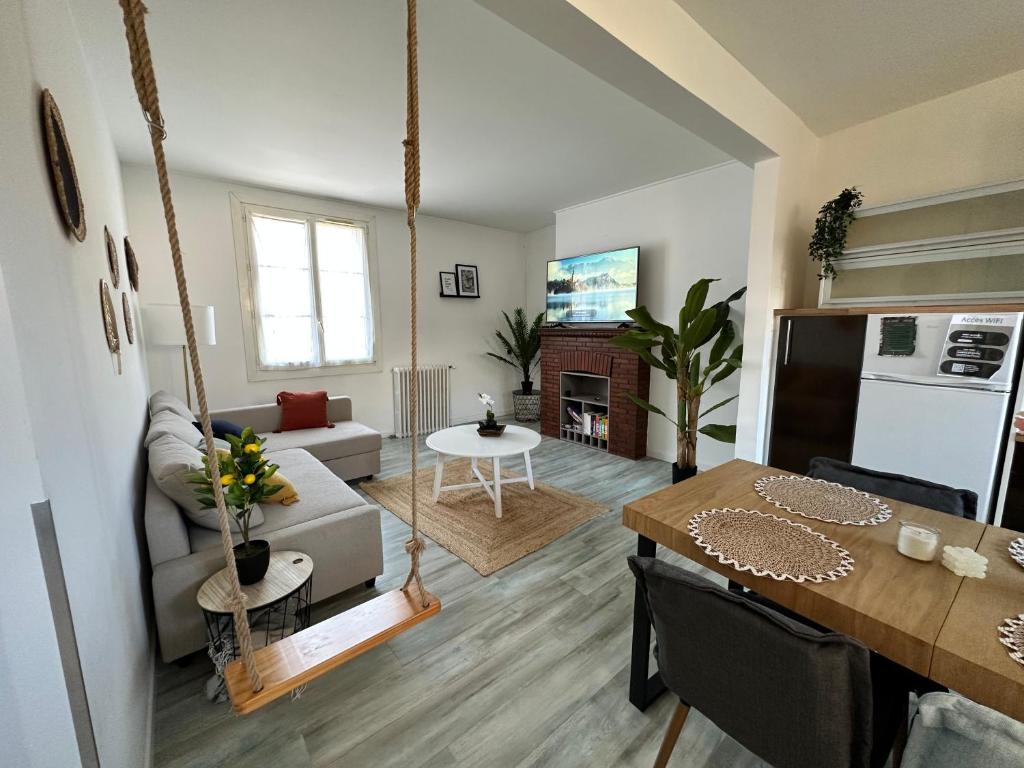 een woonkamer met een keuken en een woonkamer met een tafel bij Le Calme en Hyper-Centre in Pont-lʼÉvêque