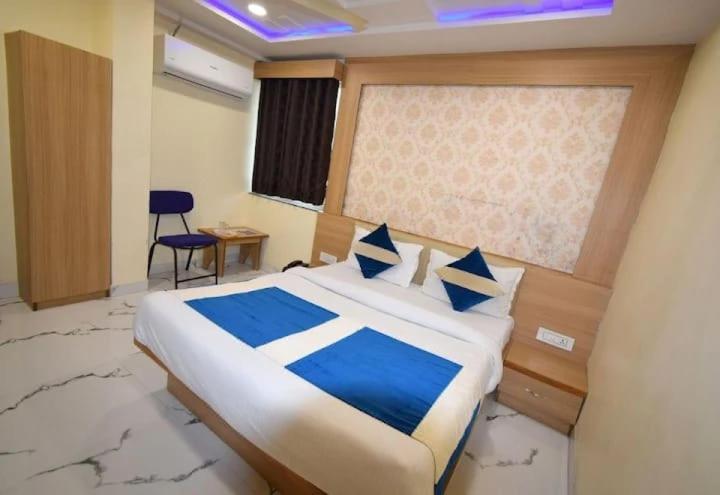 um quarto com uma cama grande com lençóis azuis e brancos em Hotel Midnight em Ahmedabad