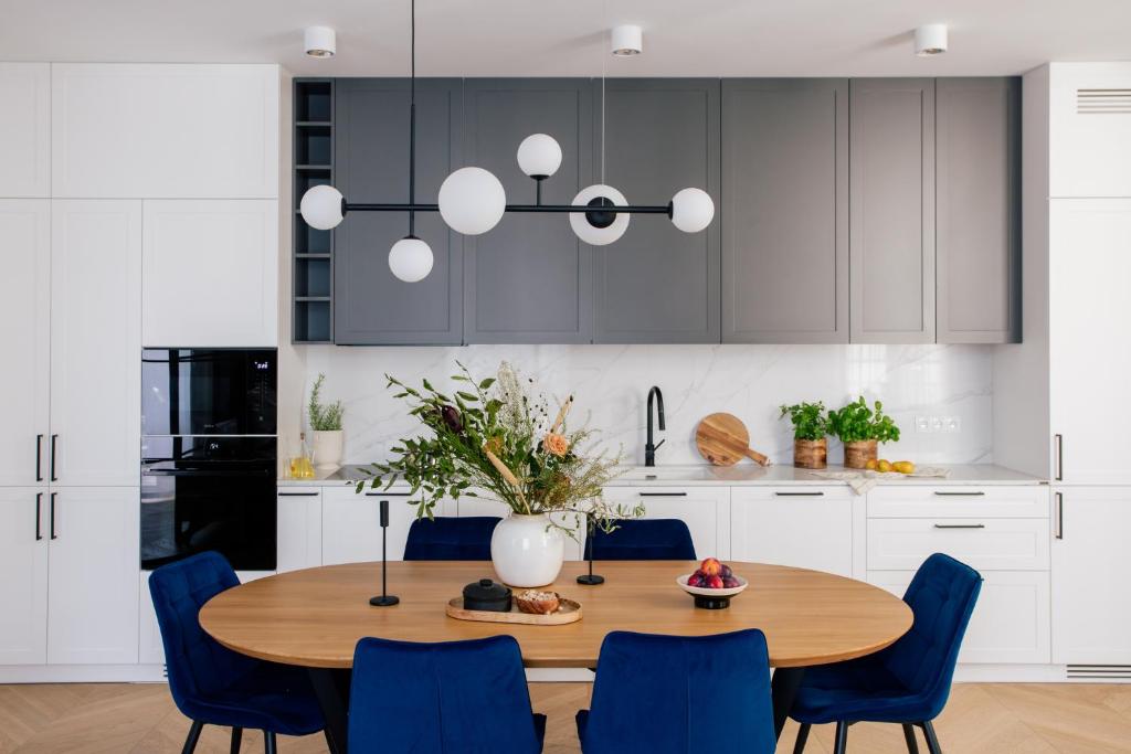 クラクフにあるTyzenhauz Apartments Superiorのキッチン(木製テーブル、青い椅子付)
