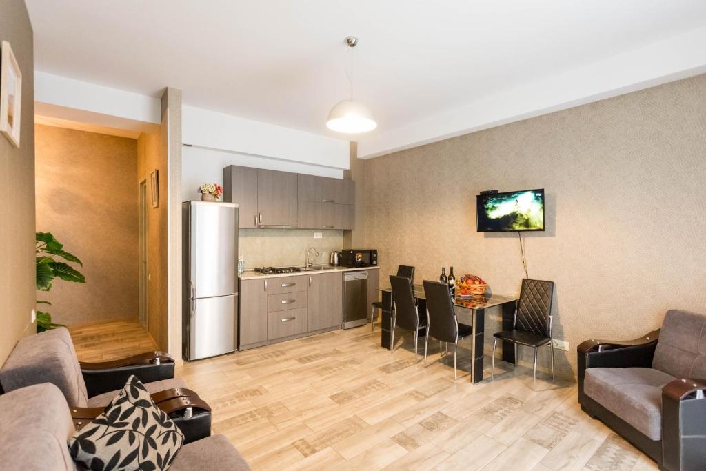 sala de estar con cocina, mesa y sillas en Cozy Apartment In The City Center, en Tiflis