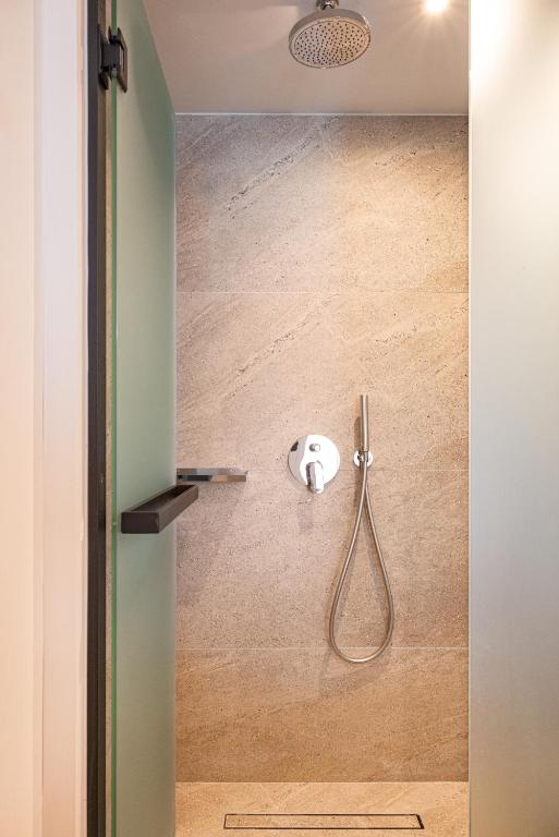 a shower with a shower head in a bathroom at Erato by Samian Mare in Karlovasi