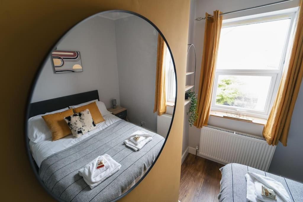 a bedroom with a bed with a mirror next to a window at Oldfield Apartments - Bath in Bath