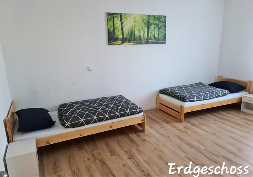 Duas camas num quarto com pisos em madeira em APARTMENT MONTEURZiMMER AM BAHNSTEIG em Kuppenheim