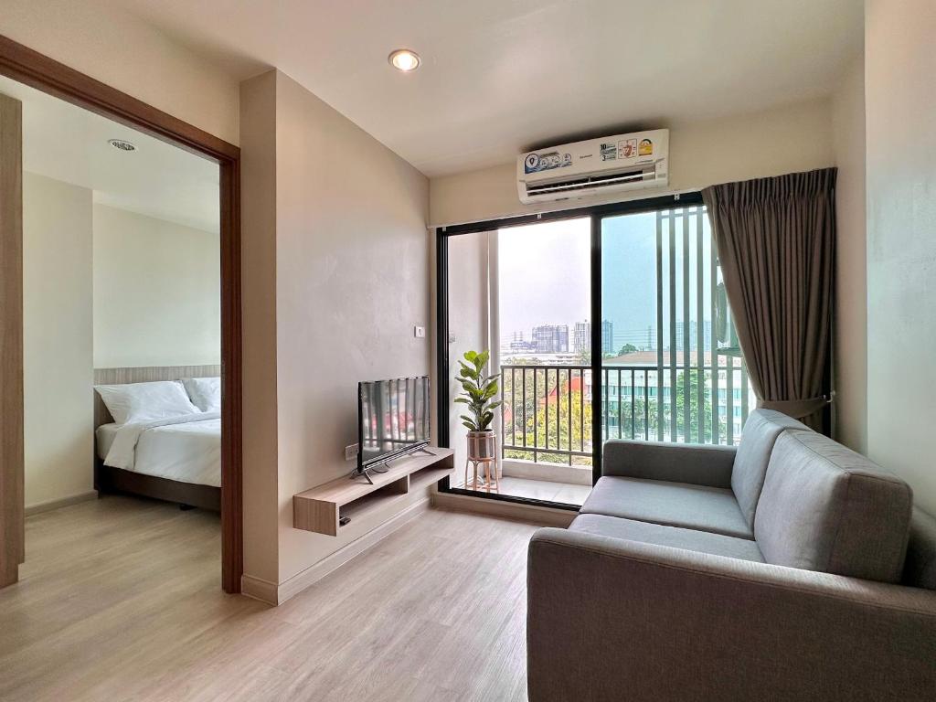 a living room with a couch and a bed and a window at TheView Chaengwattana14 เดอะวิวแจ้งวัฒนะ14 in Bangkok