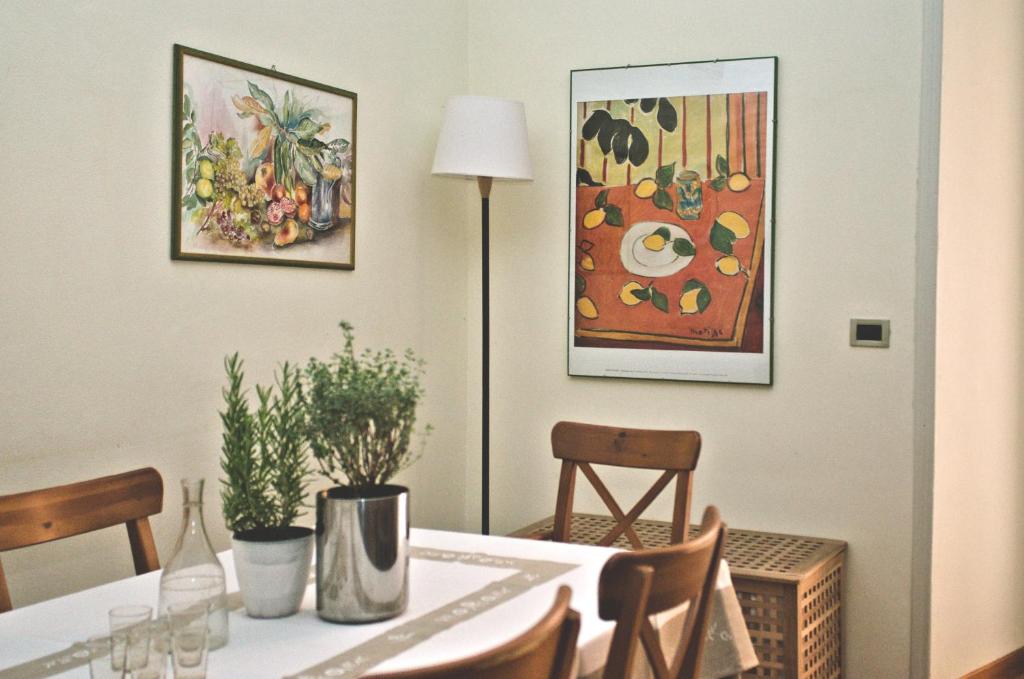 une salle à manger avec une table et un tableau dans l'établissement Minerva House, à Rome