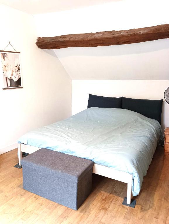 - un lit avec repose-pieds dans une chambre dans l'établissement Cottage reflet de bonheur, à Saint-Pierre-Bellevue