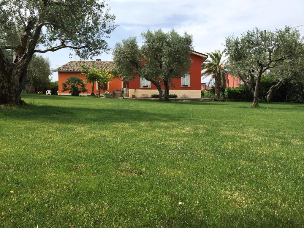 une grande cour herbeuse avec une maison en arrière-plan dans l'établissement Al Chiaro di Luna, à Paternopoli