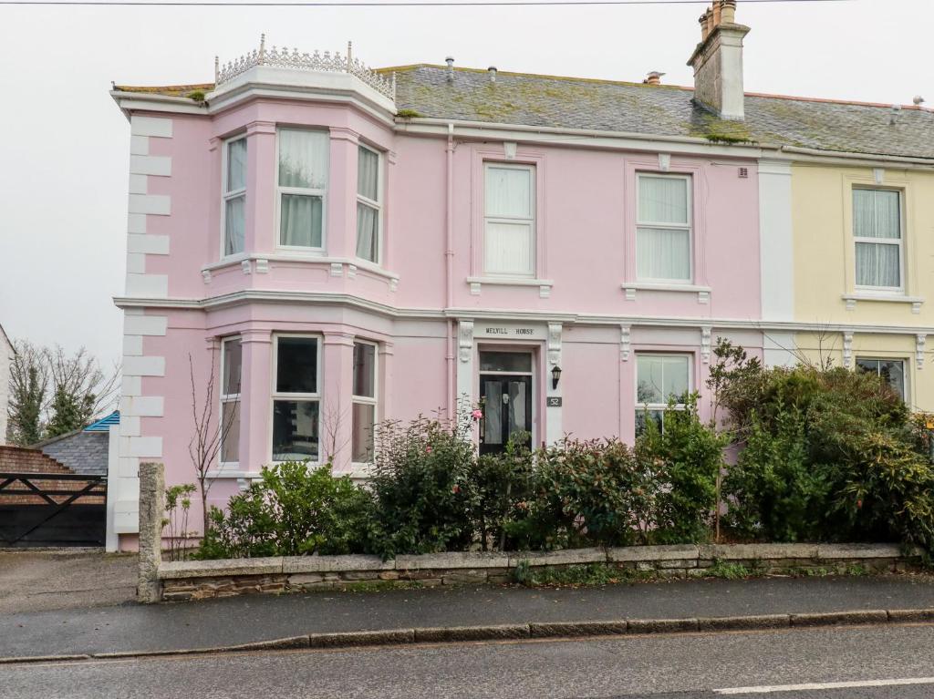 a pink house on the side of a street at Melvill House in Falmouth