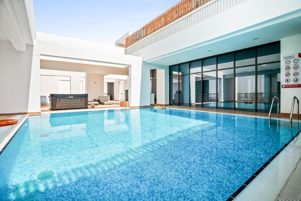 duży basen z niebieską wodą w domu w obiekcie Furnished Studio In Binghatti Apartments, Dso w Dubaju