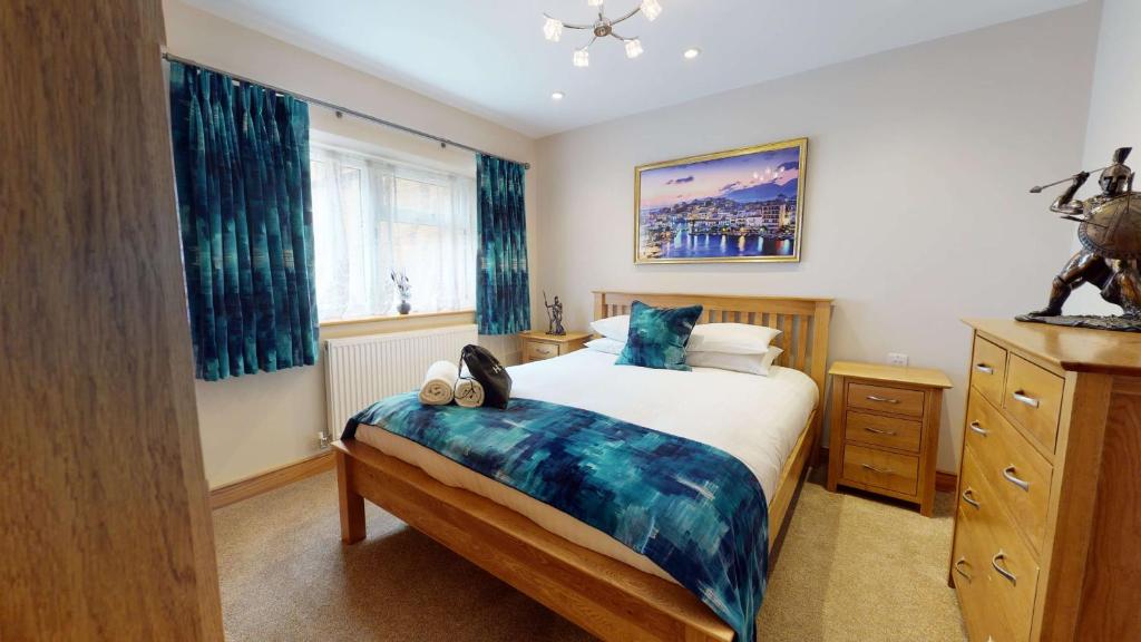 a bedroom with a large bed with blue curtains at Meadow View in Crawley