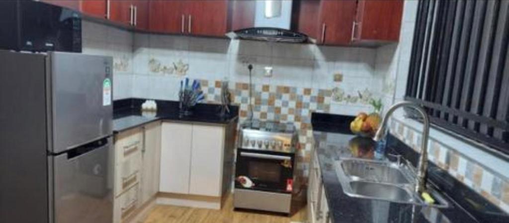 uma pequena cozinha com um frigorífico e uma máquina de lavar louça em Malachite apartments em Kampala