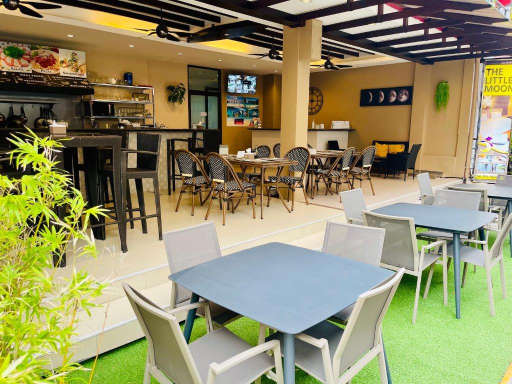 ein Restaurant mit Tischen und Stühlen und eine Bar in der Unterkunft The Little Moon Residence in Patong Beach
