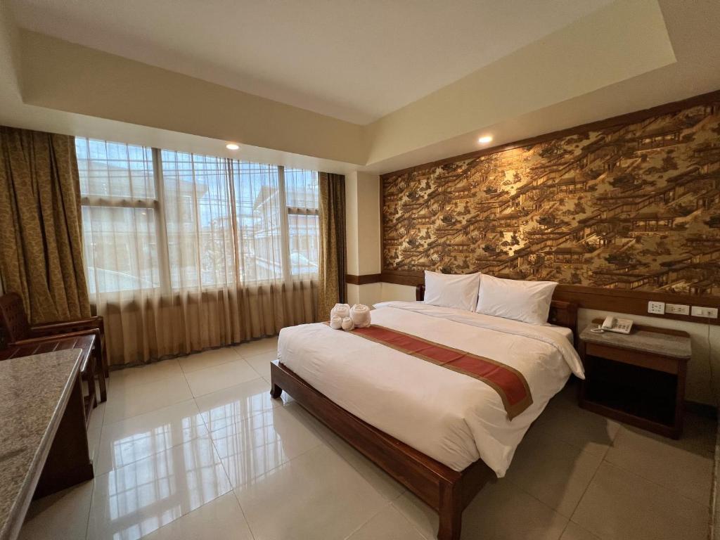a bedroom with a large bed and a stone wall at Ritz Boutique Hotel in Pattaya South