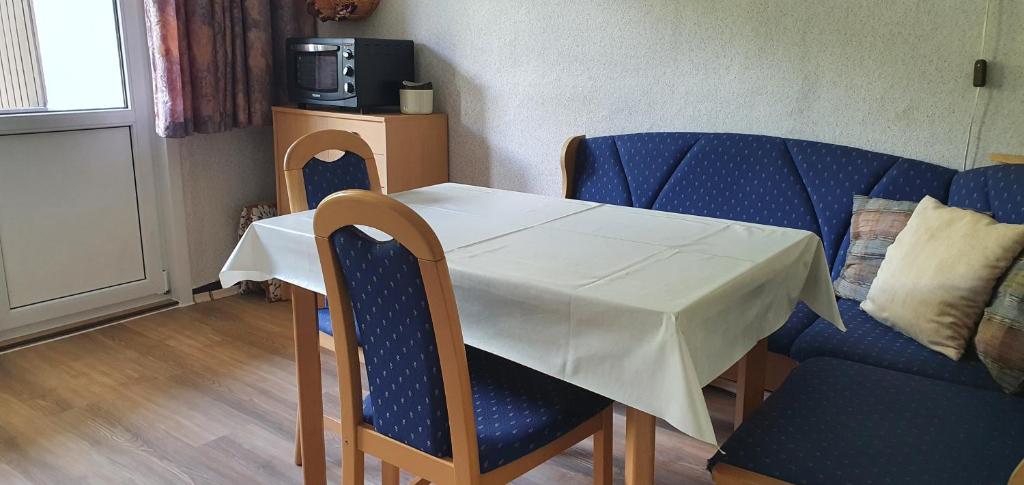 a table and chairs with a white table and a couch at Haus Bodetal in Altenbrak