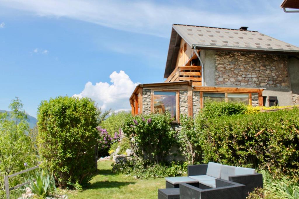 a house in the garden with bushes and trees at Gite la maison du bonheur in Eygliers