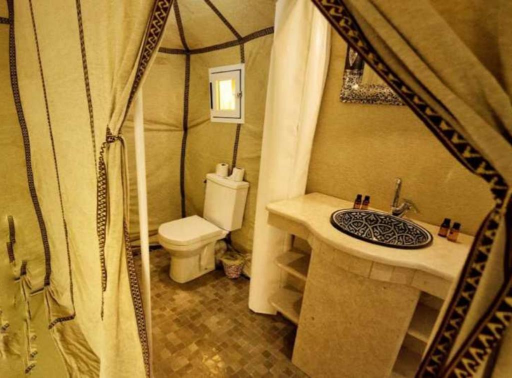 a bathroom with a sink and a toilet in a tent at Merzouga luxury magic nights in Merzouga