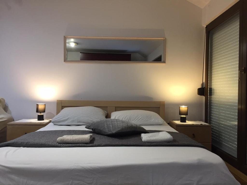 una camera da letto con un letto con due cuscini e uno specchio di Hostel Lega House a Osijek