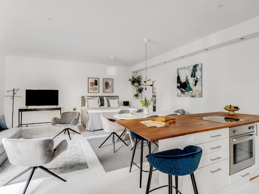 a kitchen and living room with a table and chairs at Sanders City - Spacious studio apartment in Copenhagen