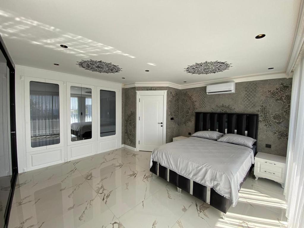 a bedroom with a large bed with marble floors at Willa Alanya in Kargicak