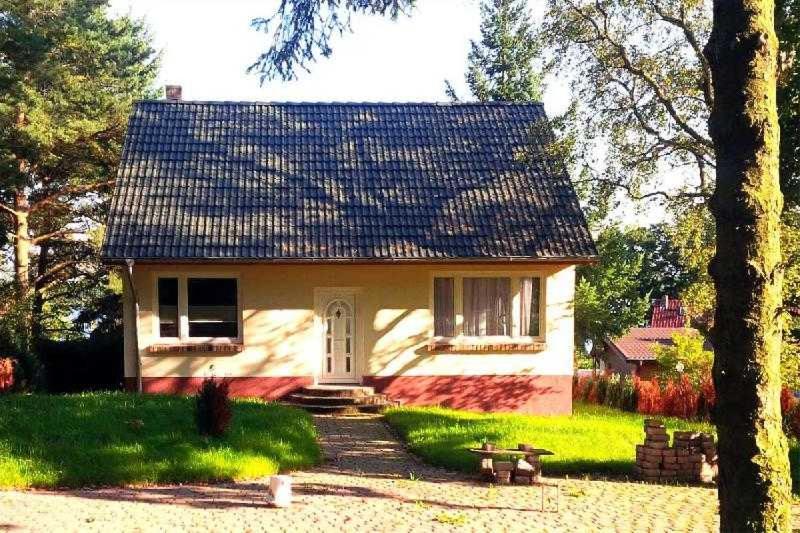 een klein wit huis met een blauw dak bij Ferienhaus Krakow am See in Krakow am See