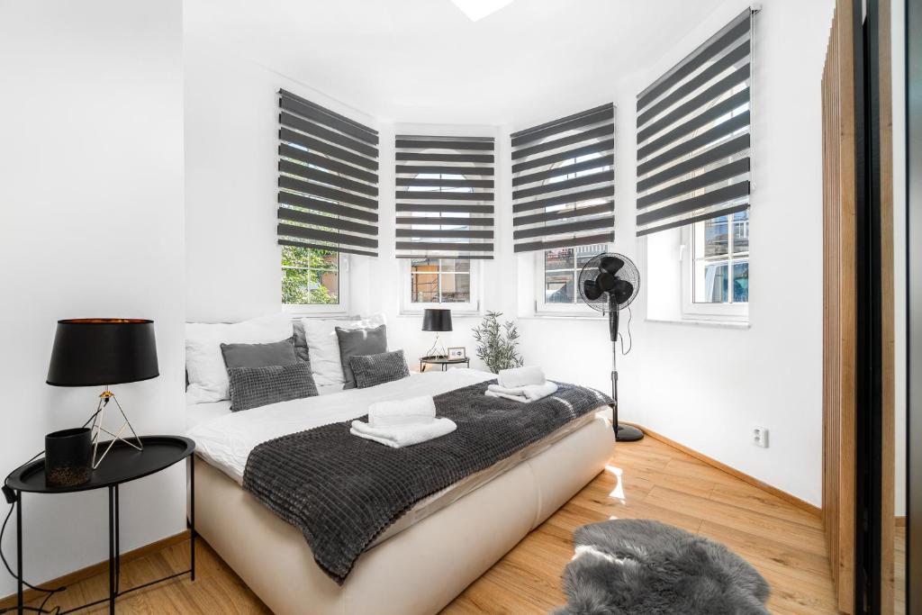 um quarto branco com uma cama grande e janelas em Beautiful Apartments With Parking In a Quiet Location em Ostrava