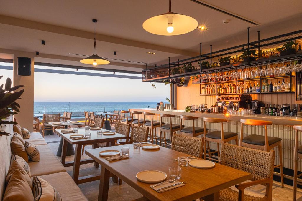 a restaurant with tables and a view of the ocean at Erato by Samian Mare in Karlovasi