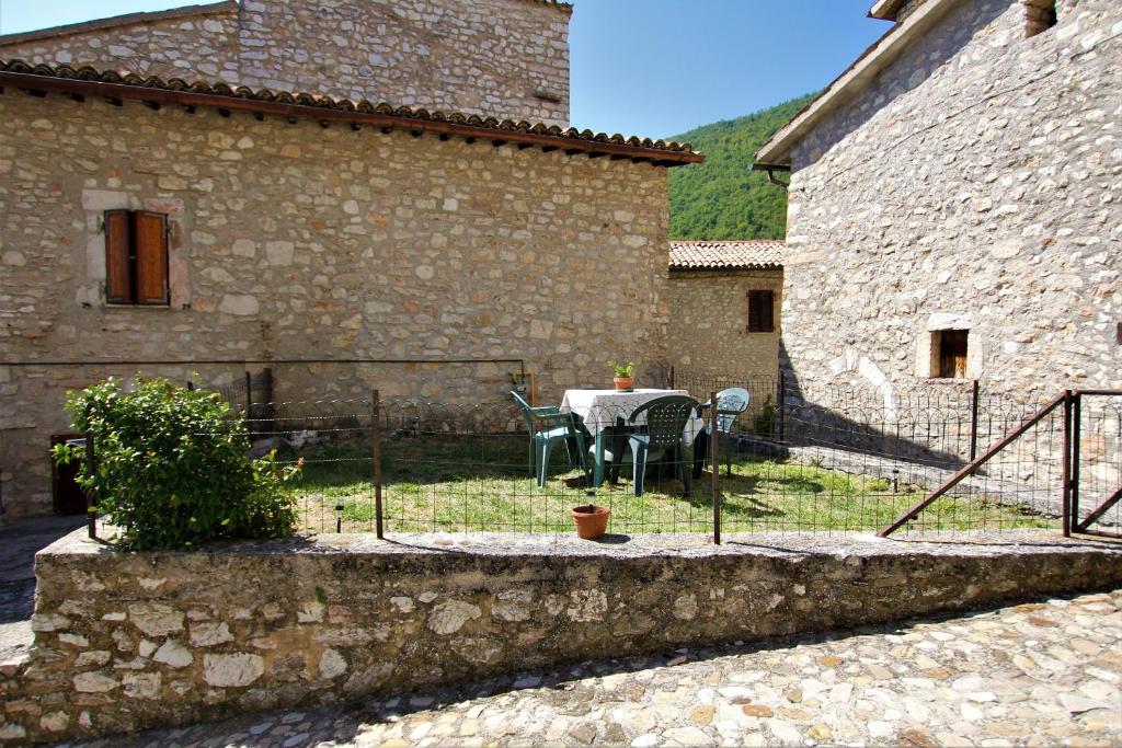 un patio avec une table et des chaises devant un bâtiment dans l'établissement Il Rustico di Meggiano, à Meggiano