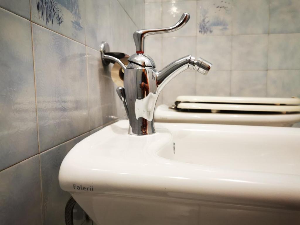 a bathroom sink with a faucet on top of a toilet at Dimora alla Villa in Ostuni