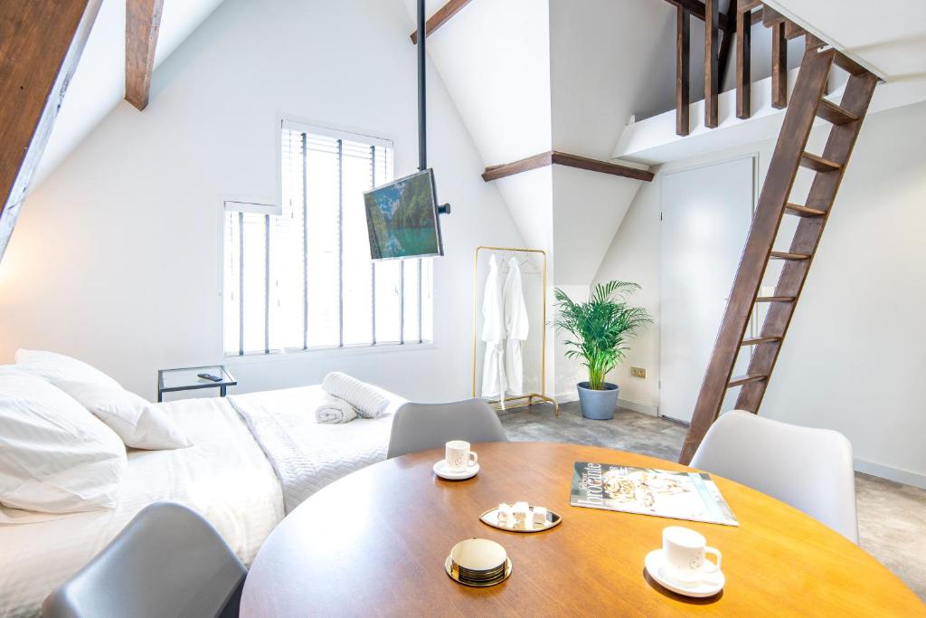 um quarto com uma cama grande e uma mesa de madeira em New Family XL Utopia Top floor app4 Rotterdam-Schiedam City Centre Central em Schiedam