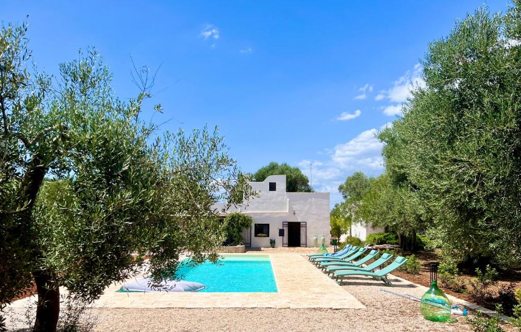 eine Gruppe von Liegestühlen neben einem Pool in der Unterkunft Le Lamie di Ostuni in San Michele Salentino